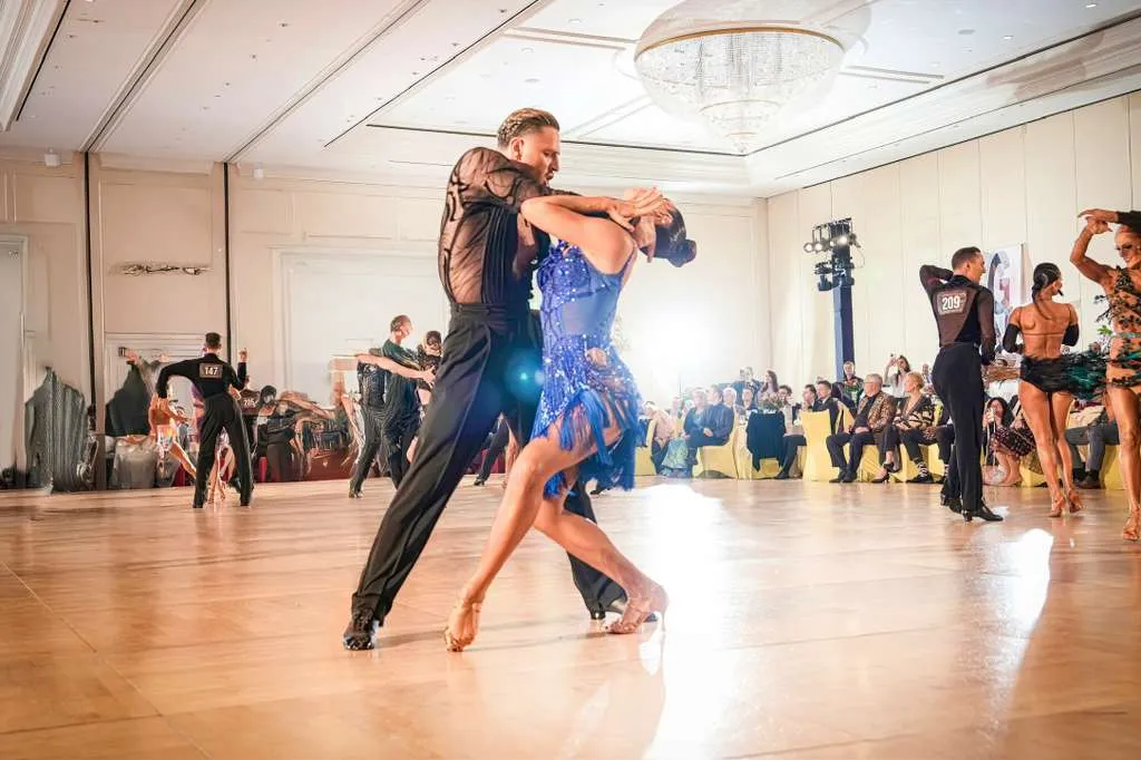 Latin competition dance couple in a blue dress