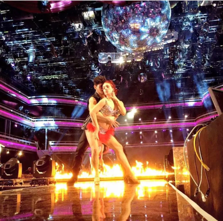 A featured male dancer performing beneath stage lights