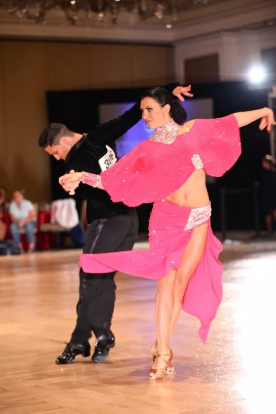 A young ballroom dance couple performing at a competition