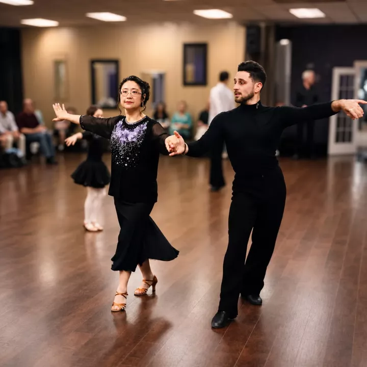 Adult student practicing ballroom dance with an instructor