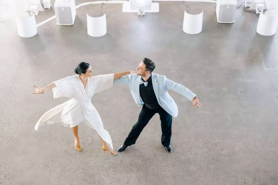 A ballroom couple practicing together in a bright dance studio
