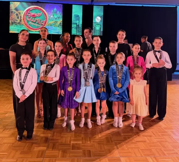Youth ballroom students and instructors celebrating together after a competition